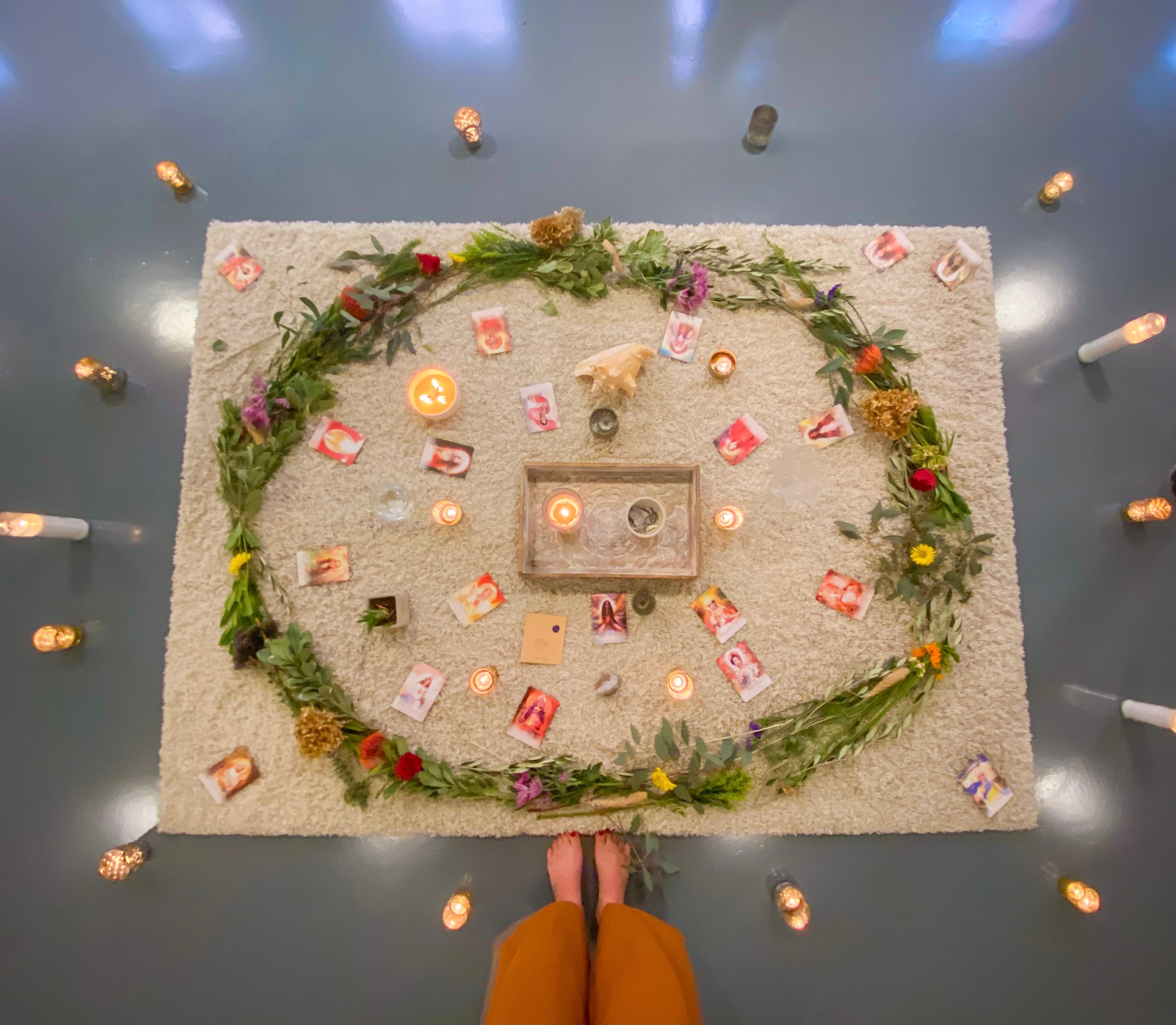 A softly styled ritual gathering of candles and botanicals